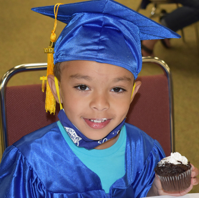 Little Learners graduate eating a cupcake